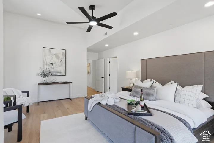 Spacious interior featuring a vaulted ceiling with a modern ceiling fan, recessed lighting, and wood-finish flooring