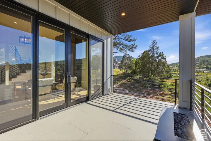 Covered outdoor patio with a plank ceiling, board and batten siding, and a linear rock-filled fire pit