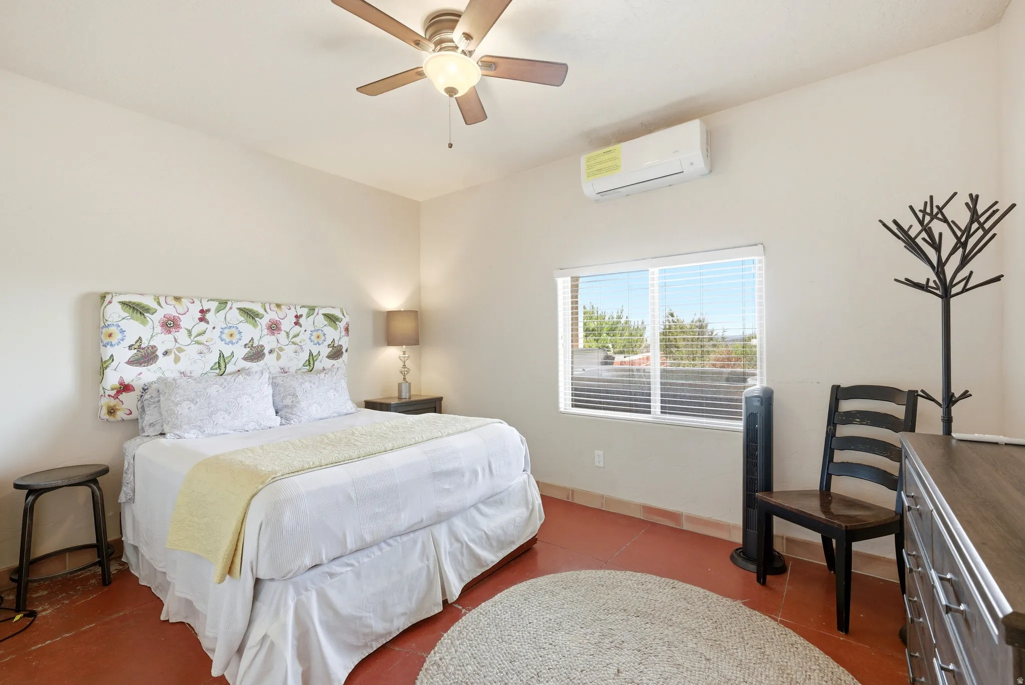Bedroom featuring a ceiling fan, window with blinds, and mini-split air conditioning unit