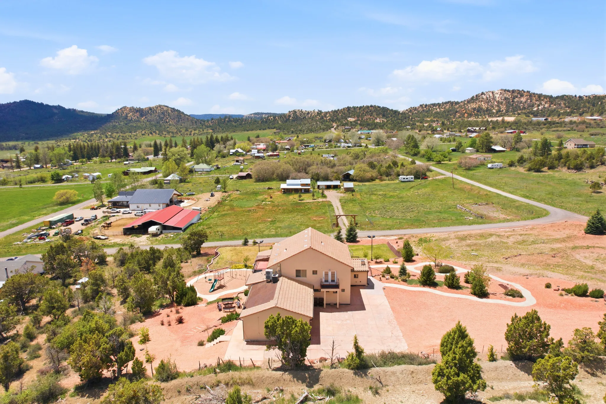Expansive property featuring a stucco-exterior residence with a multi-level design and a covered entry