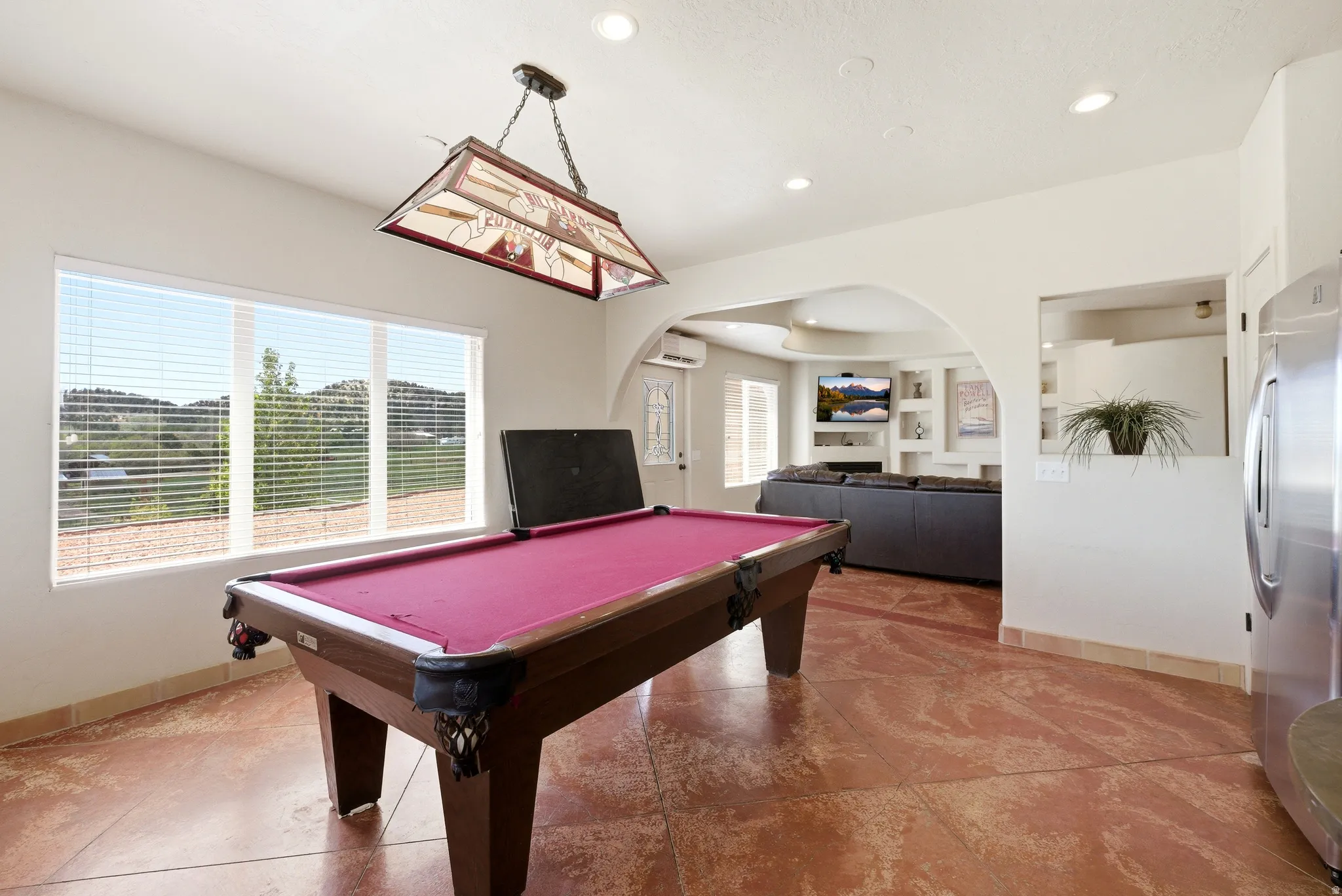 Spacious recreation area featuring a stained concrete floor, large picture windows, and recessed lighting