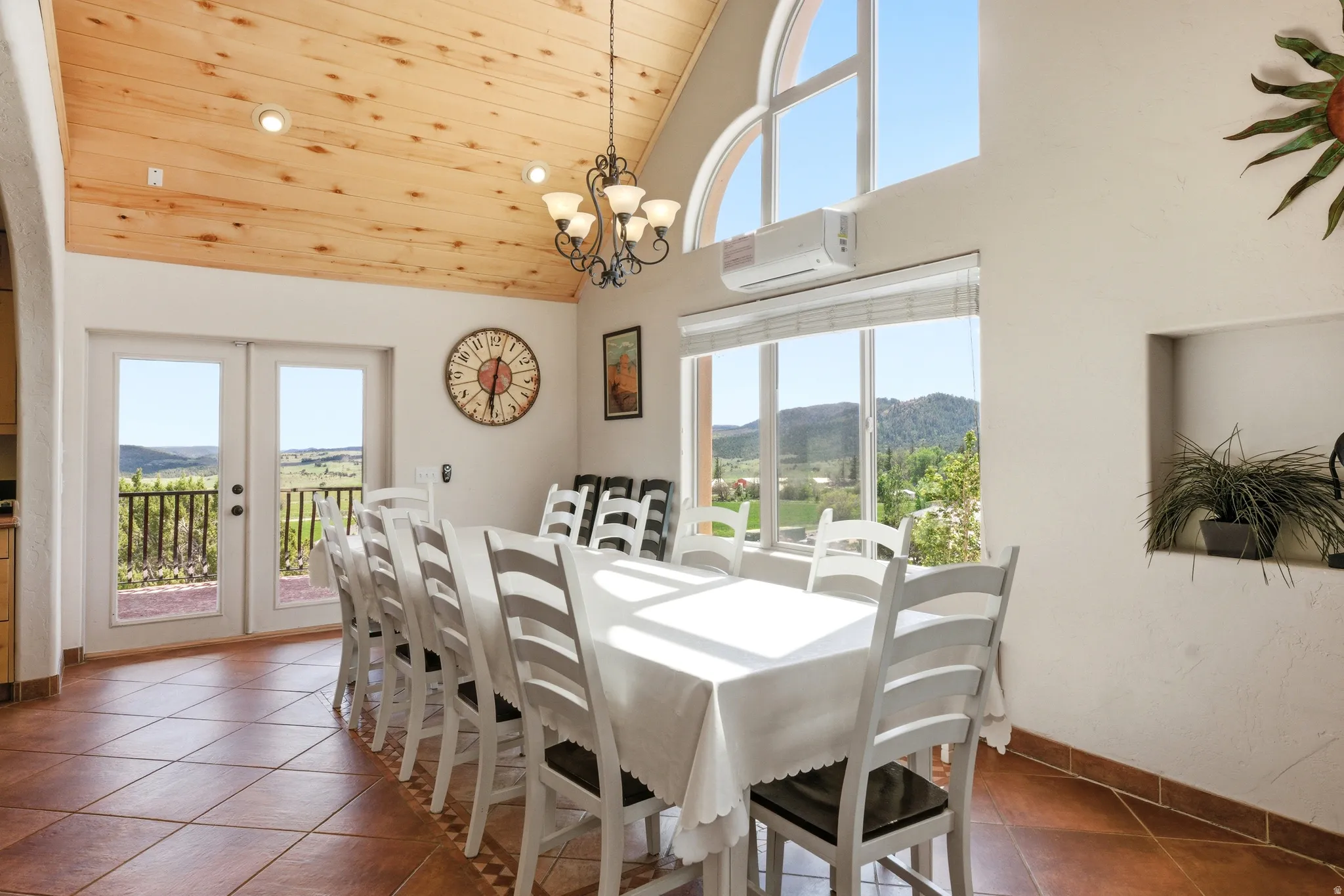 Vaulted wood-finish ceiling with recessed lighting and a decorative chandelier