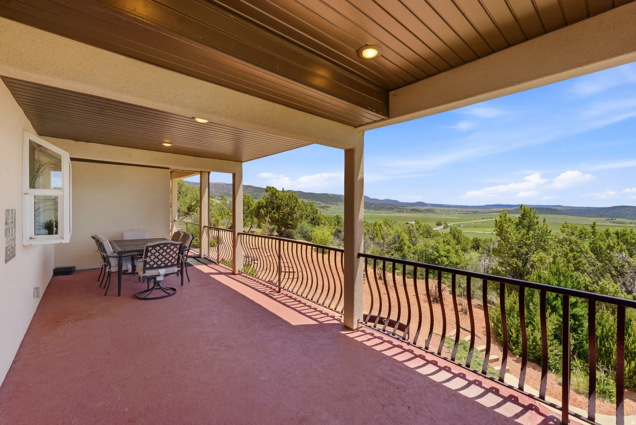 Covered outdoor patio with a red-hued concrete surface