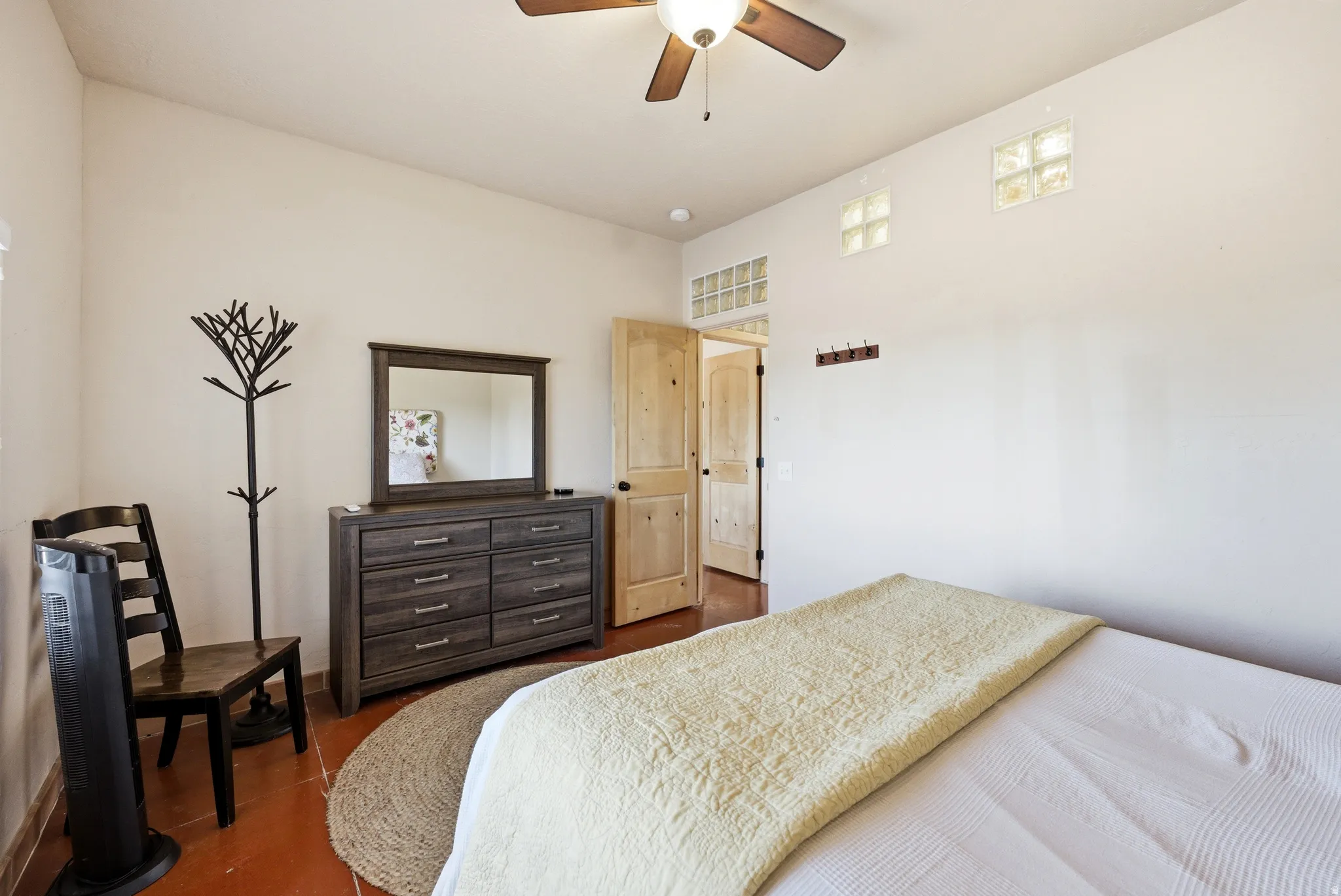 Interior space featuring a ceiling fan with integrated lighting, wood-finish flooring, and glass block windows