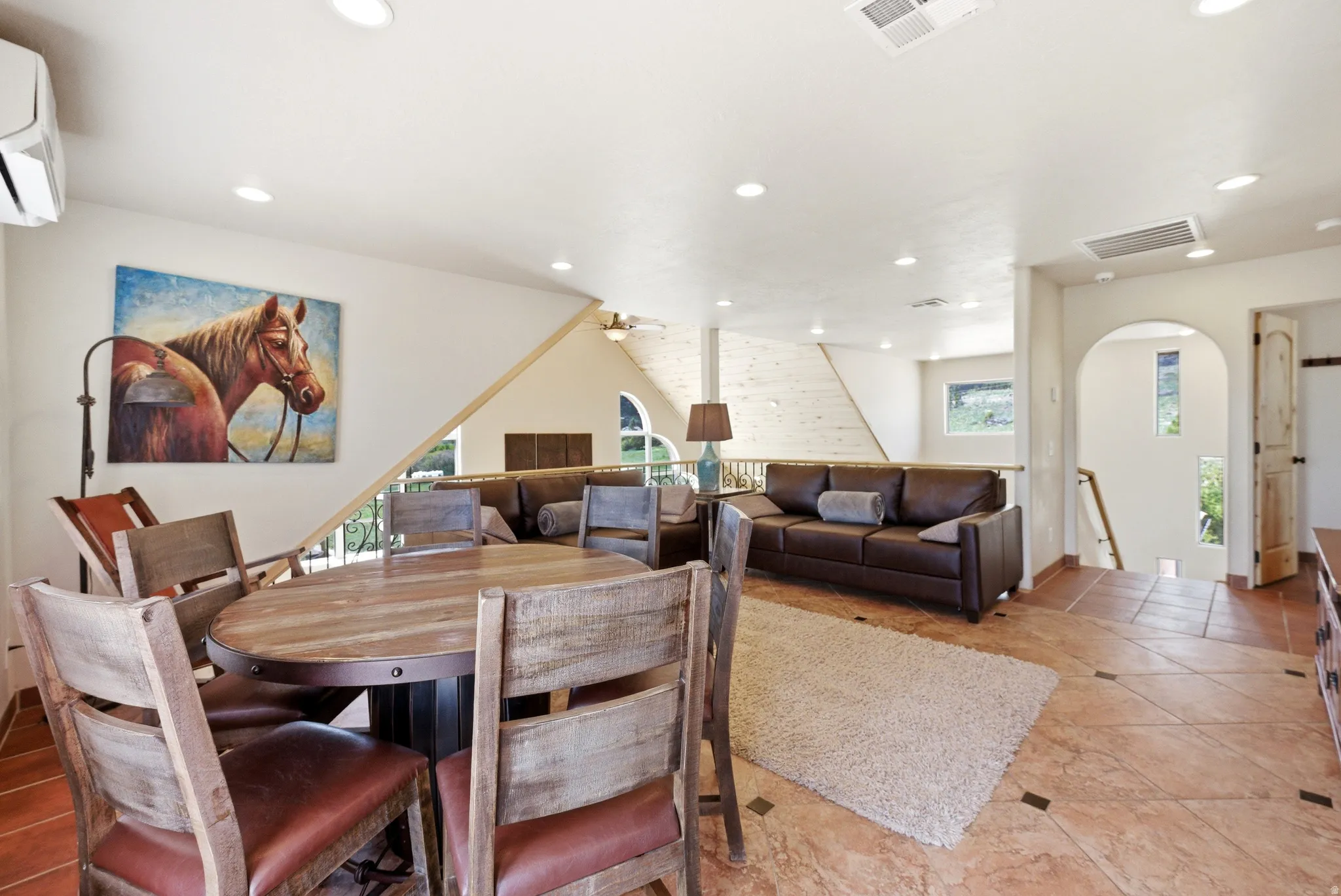 Open-concept living area with terra cotta style tile flooring and recessed lighting