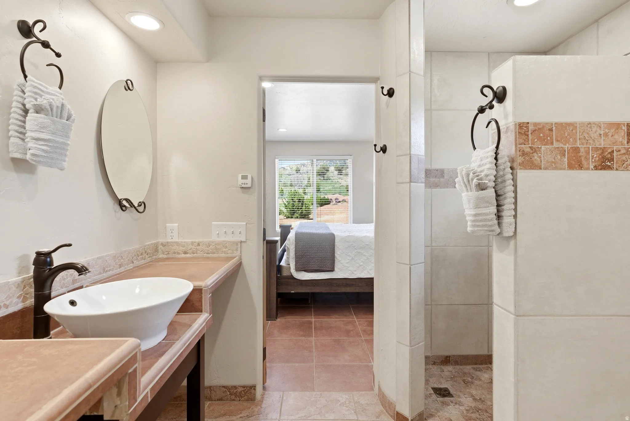 Bathroom featuring a vessel sink, oil-rubbed bronze faucet, and tiled countertops