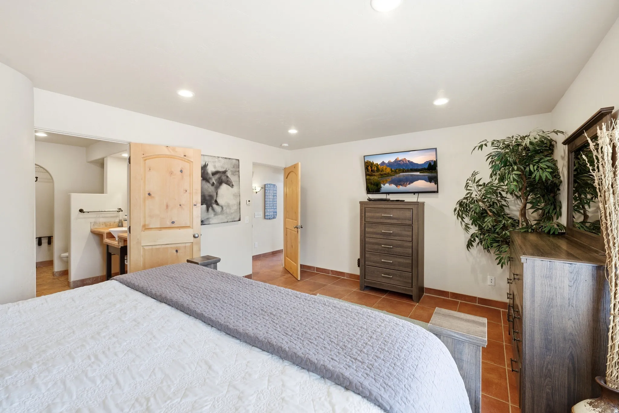 Bedroom featuring terracotta-style tile flooring, recessed lighting, and a solid wood arched door