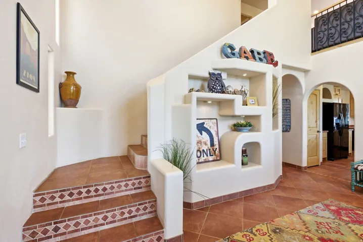 Staircase featuring decorative tile risers and terra cotta flooring