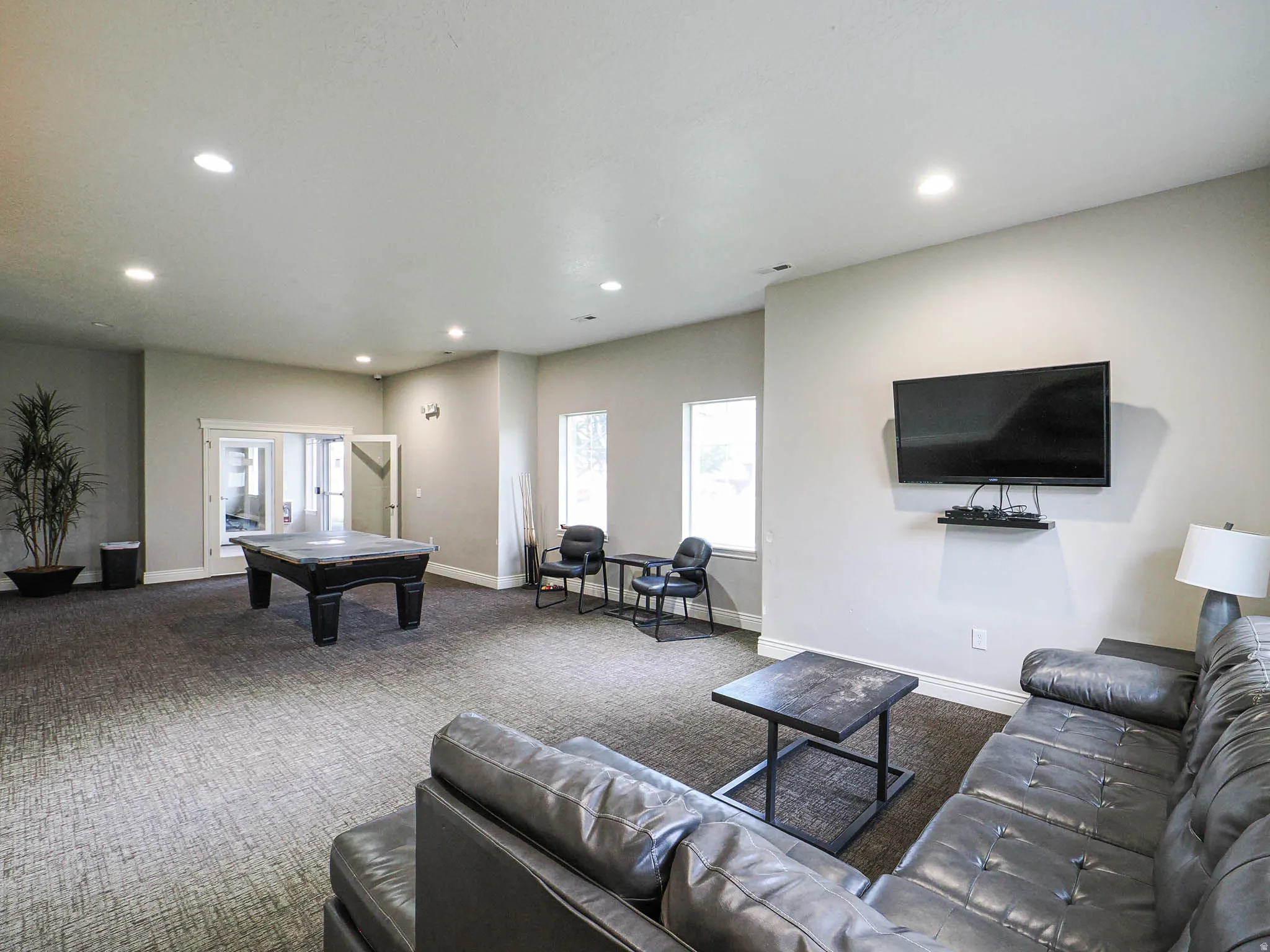 Spacious recreation area featuring recessed lighting, carpet flooring, and multiple windows