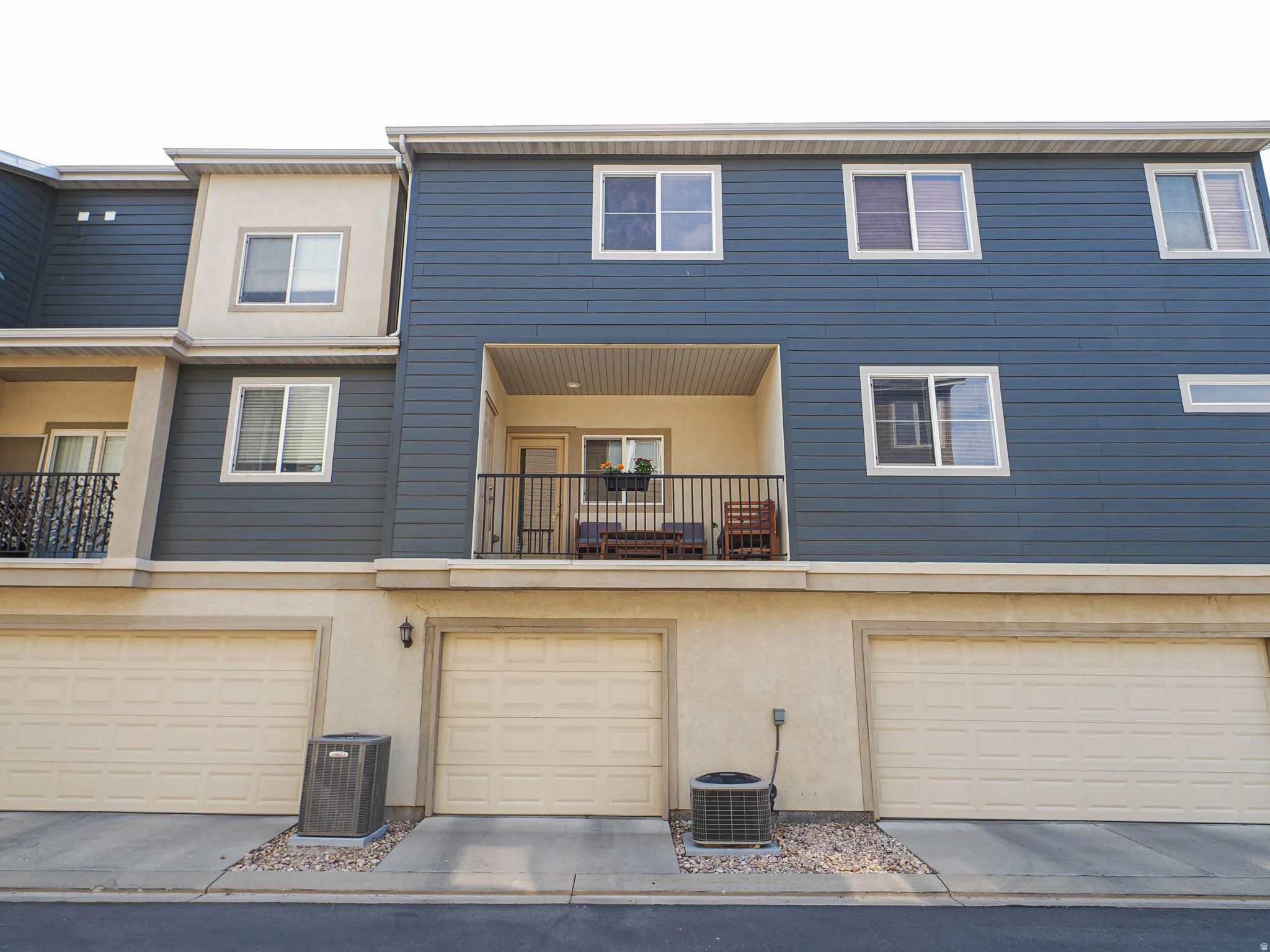 Multi-level exterior with blue siding and stucco finishes