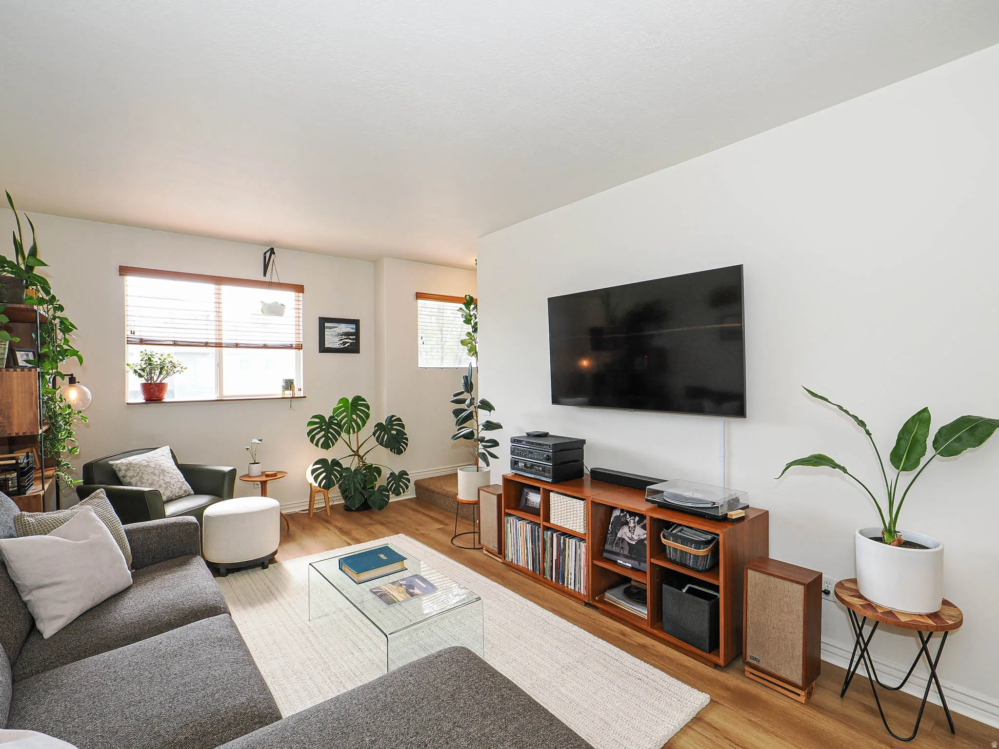 Living area featuring wood-finish flooring, a wall-mounted television, and a built-in media console