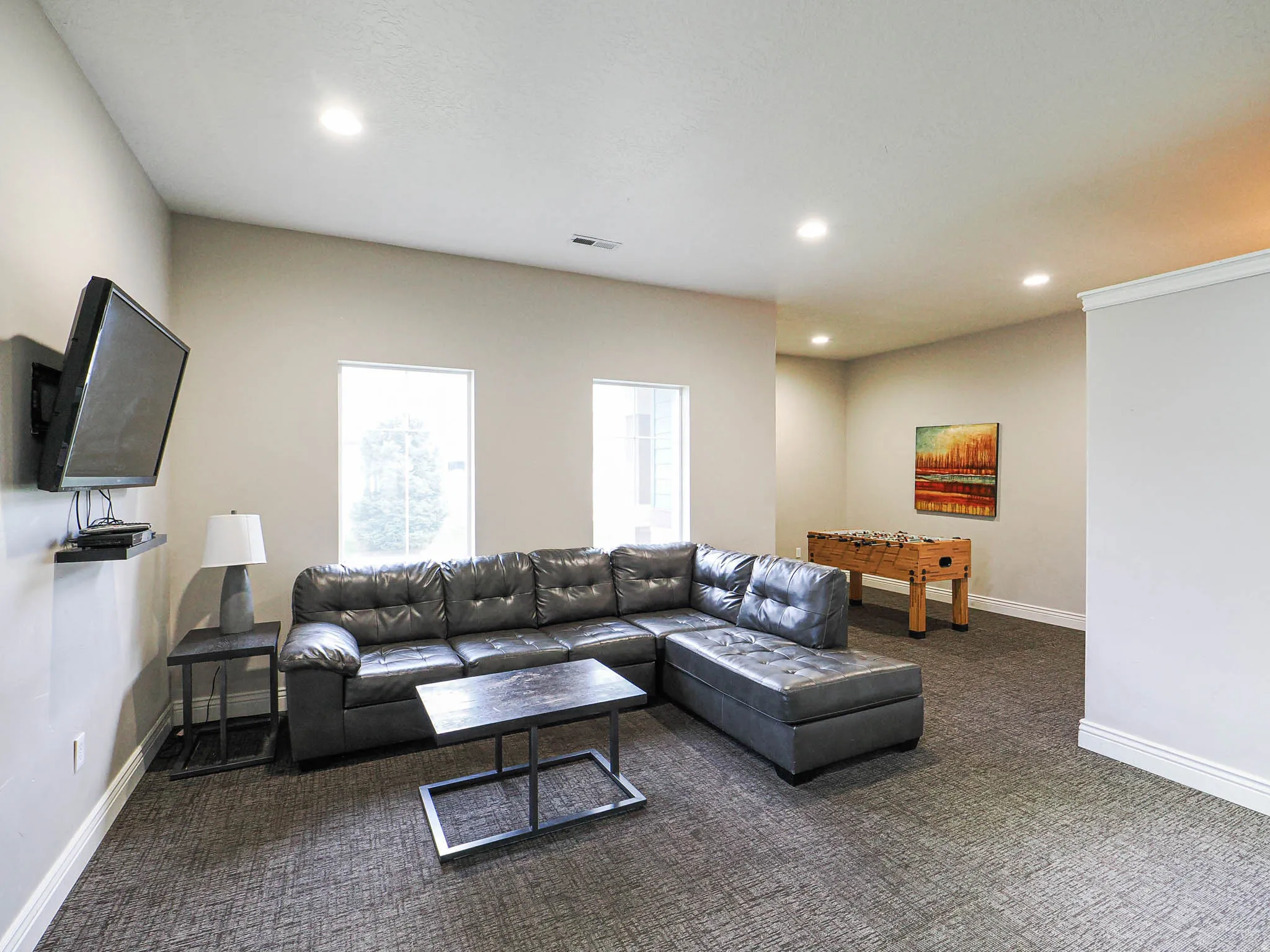 Open concept room featuring textured gray carpeting, neutral-toned walls, and recessed lighting