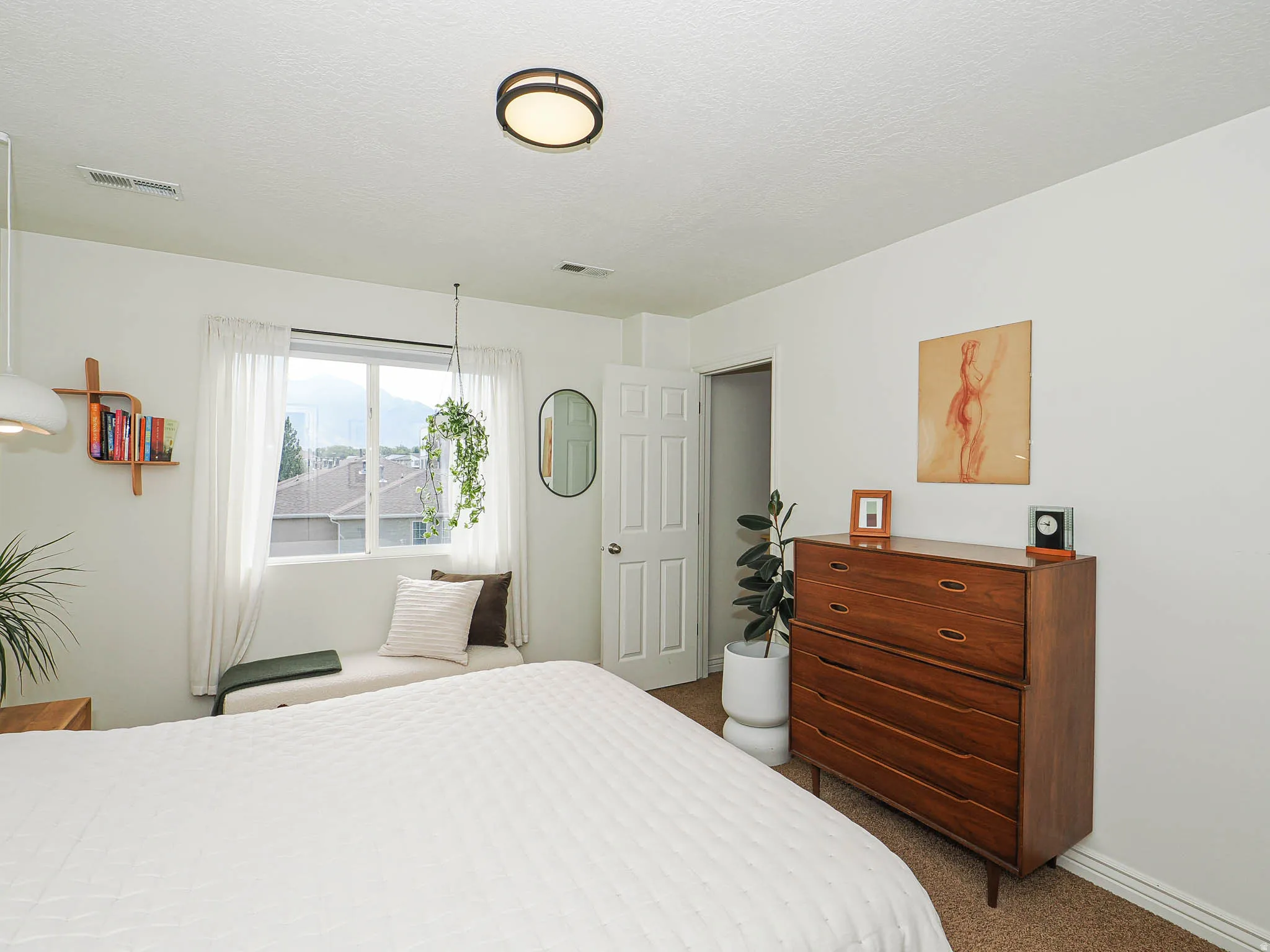 Window with mountain scenery, recessed window bench, contemporary ceiling light fixture, built-in shelving, and neutral wall tones