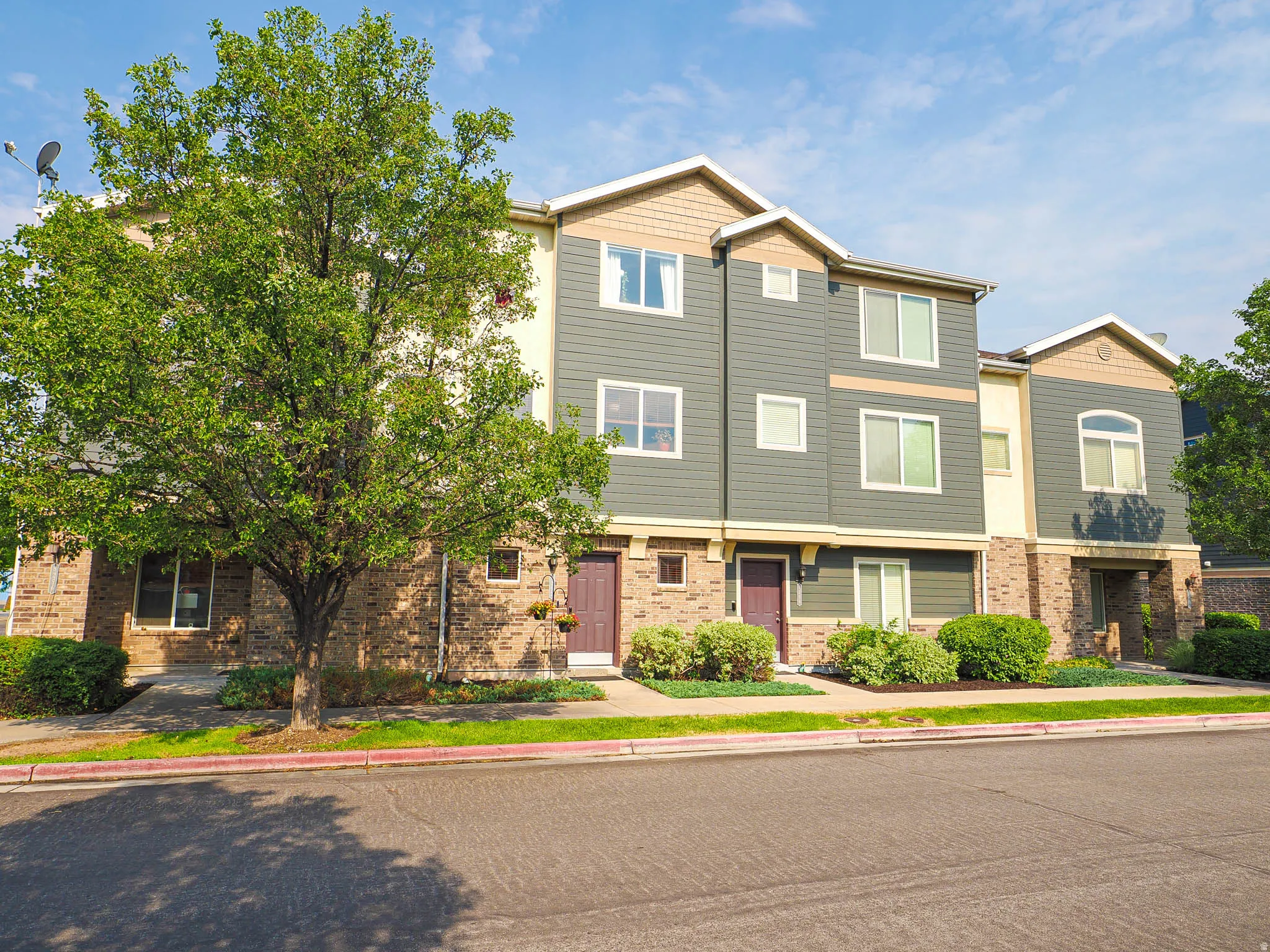 Modern townhome exterior featuring brick and horizontal siding accents