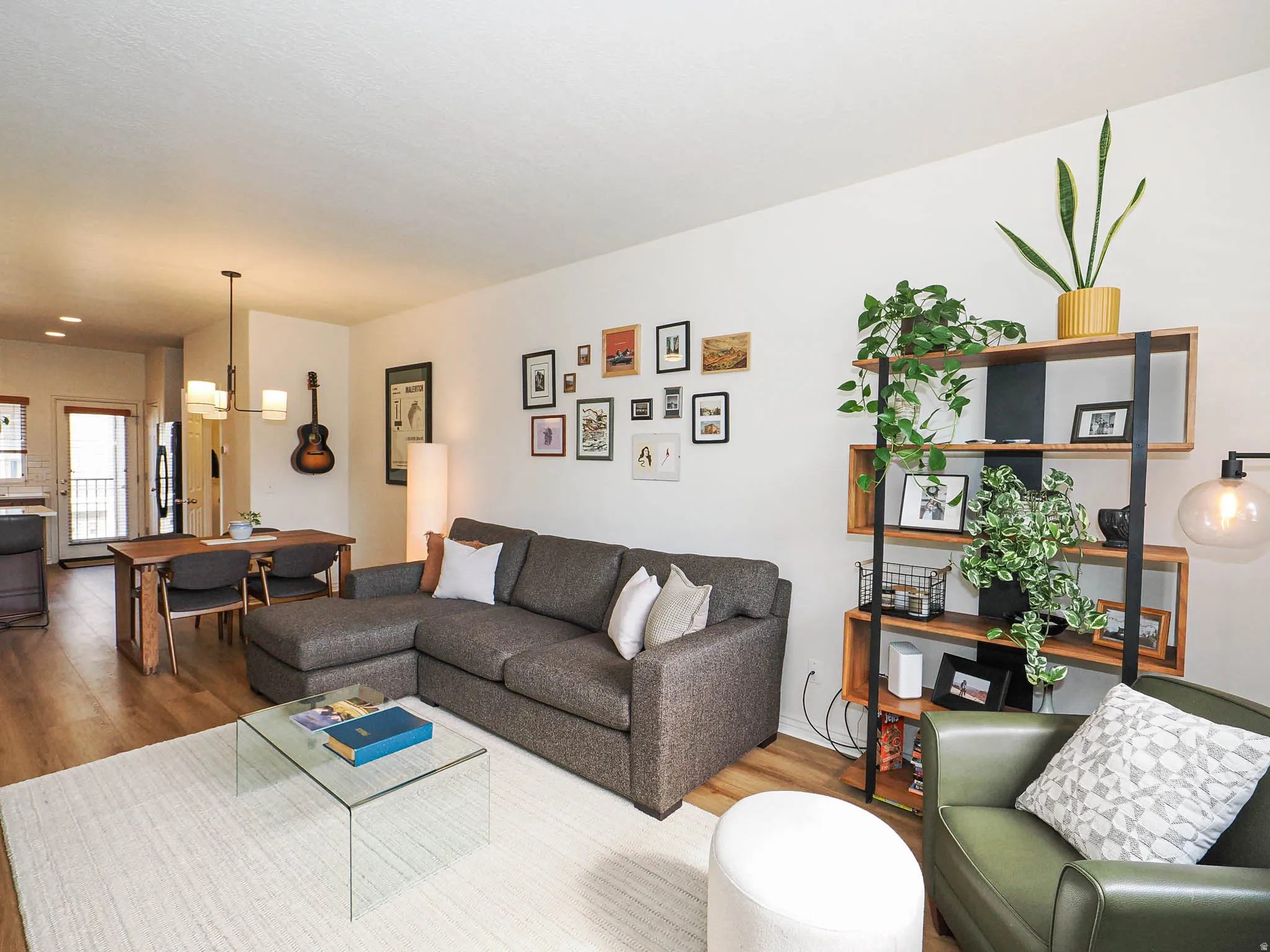 Open-concept living area featuring wood-finish flooring, recessed lighting, and a modern chandelier