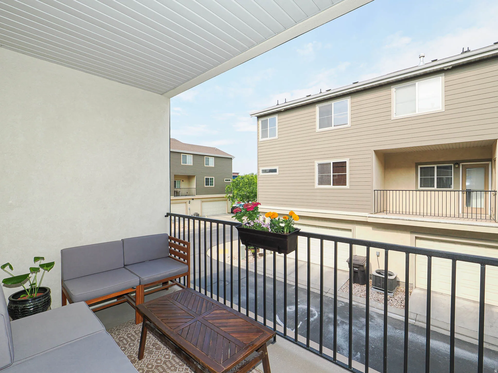 Covered outdoor balcony featuring a textured stucco wall and white slatted ceiling