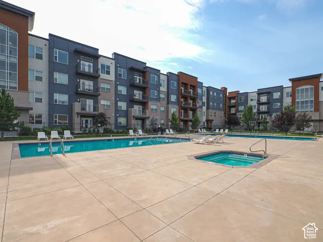 Outdoor swimming pool area featuring a large rectangular pool and a separate square spa