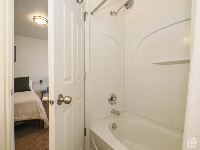 Fiberglass tub and shower combination with chrome fixtures and integrated shelving
