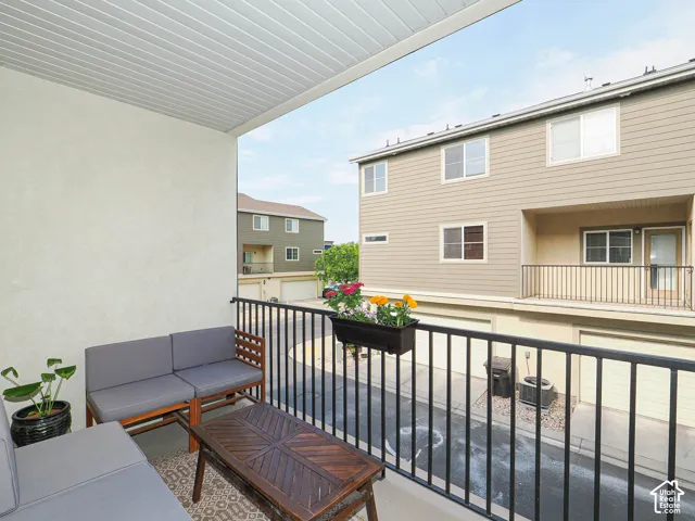 Covered outdoor balcony featuring a textured stucco wall and white slatted ceiling
