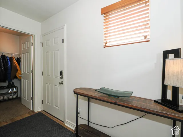 Entryway featuring a panel door, built-in closet with bifold doors, and wood-finish flooring