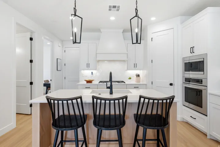 Modern kitchen featuring an expansive island with wood-finish paneling and a light-toned countertop