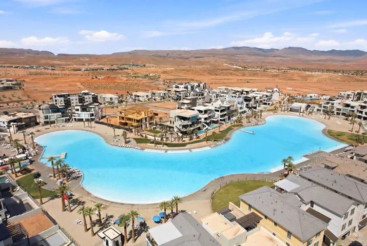 Expansive artificial lagoon with sandy shores and surrounding contemporary residential buildings