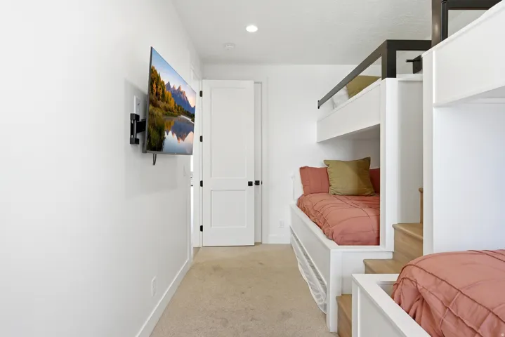 Built-in bunk beds with integrated wood-finish steps and black metal railings