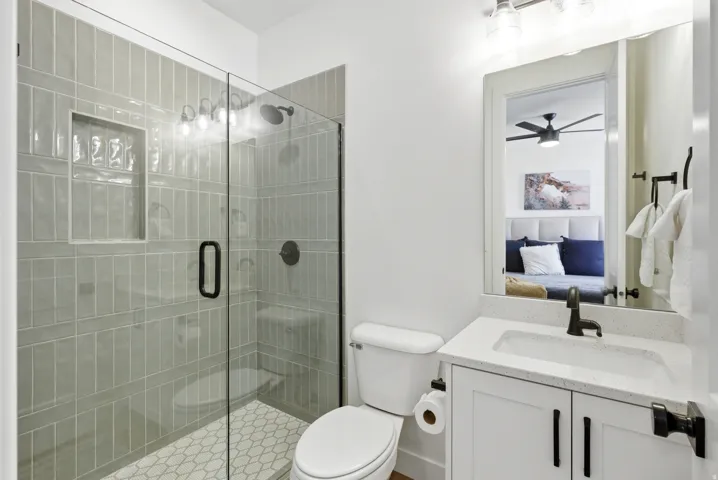 Contemporary bathroom featuring a glass-enclosed shower with subway tile surround and integrated niche