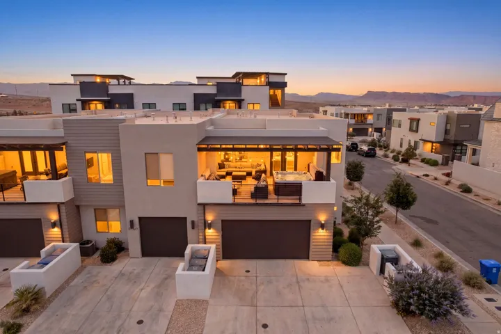 Contemporary multi-story residence featuring a flat roofline and a private upper-level balcony with a hot tub