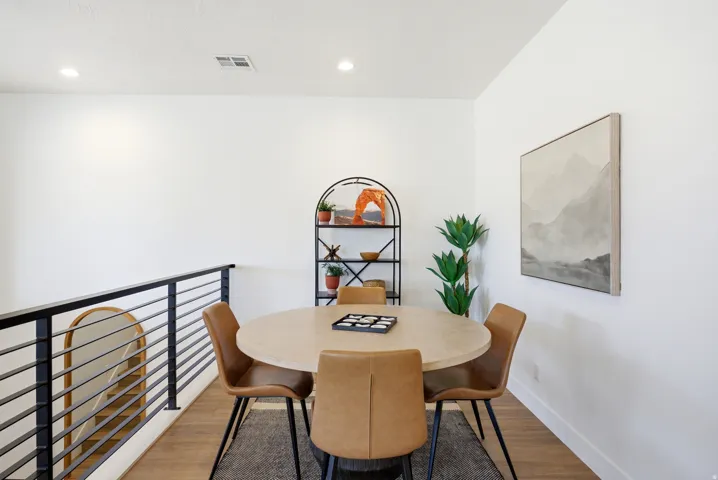 Upper-level room featuring recessed lighting, a modern horizontal bar railing, and wood-finish flooring