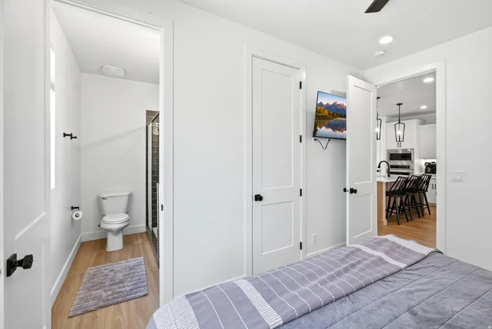 White paneled doors with black hardware, recessed lighting, and wood-finish flooring