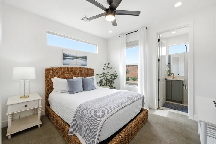Carpeted bedroom featuring a transom window and a full-height window with white drapes