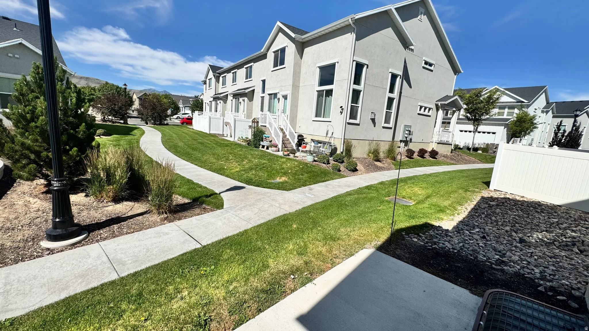 Modern townhome exterior with light gray stucco siding and white trim