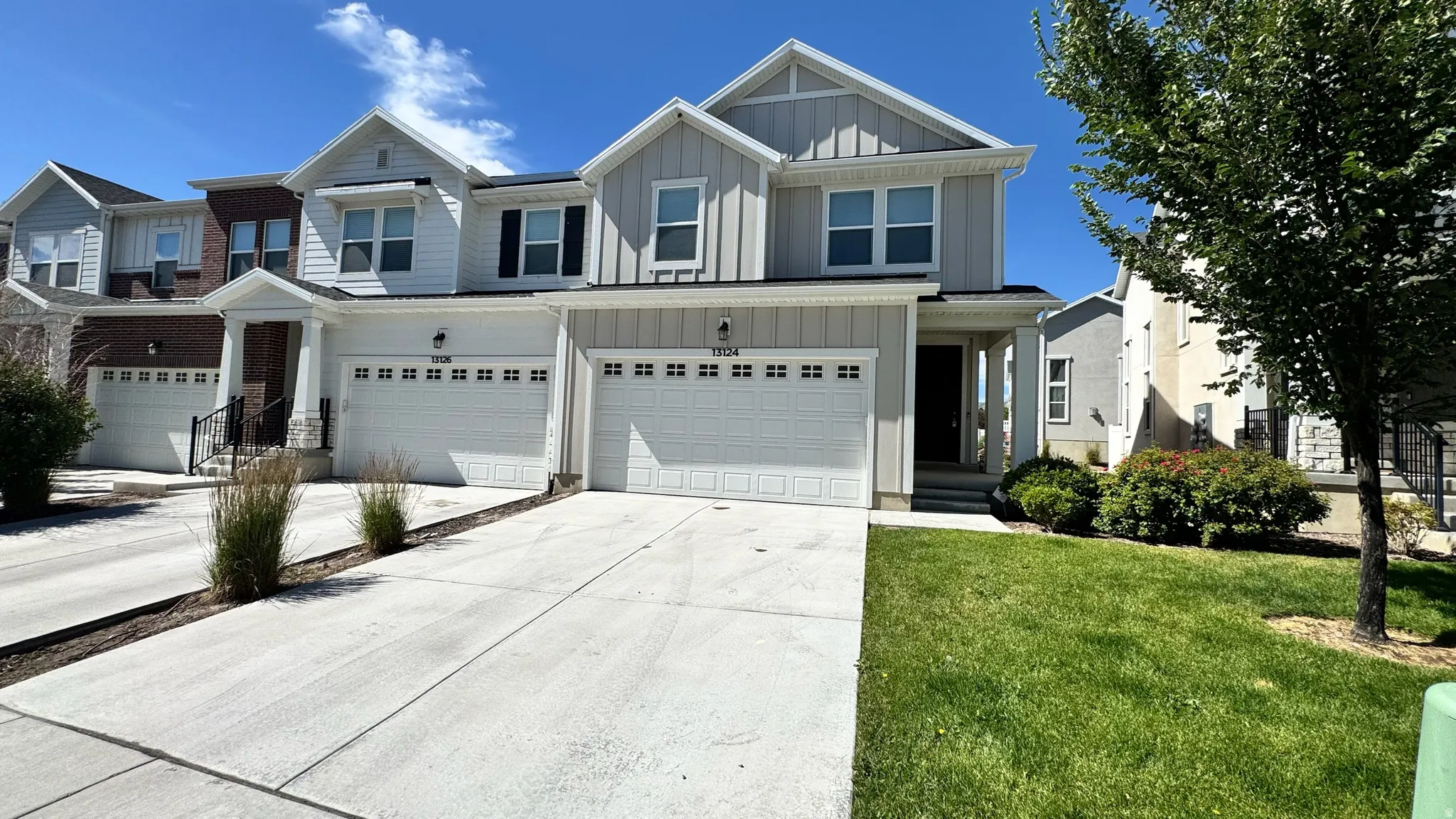 Modern townhome exterior with light gray vertical siding and white trim