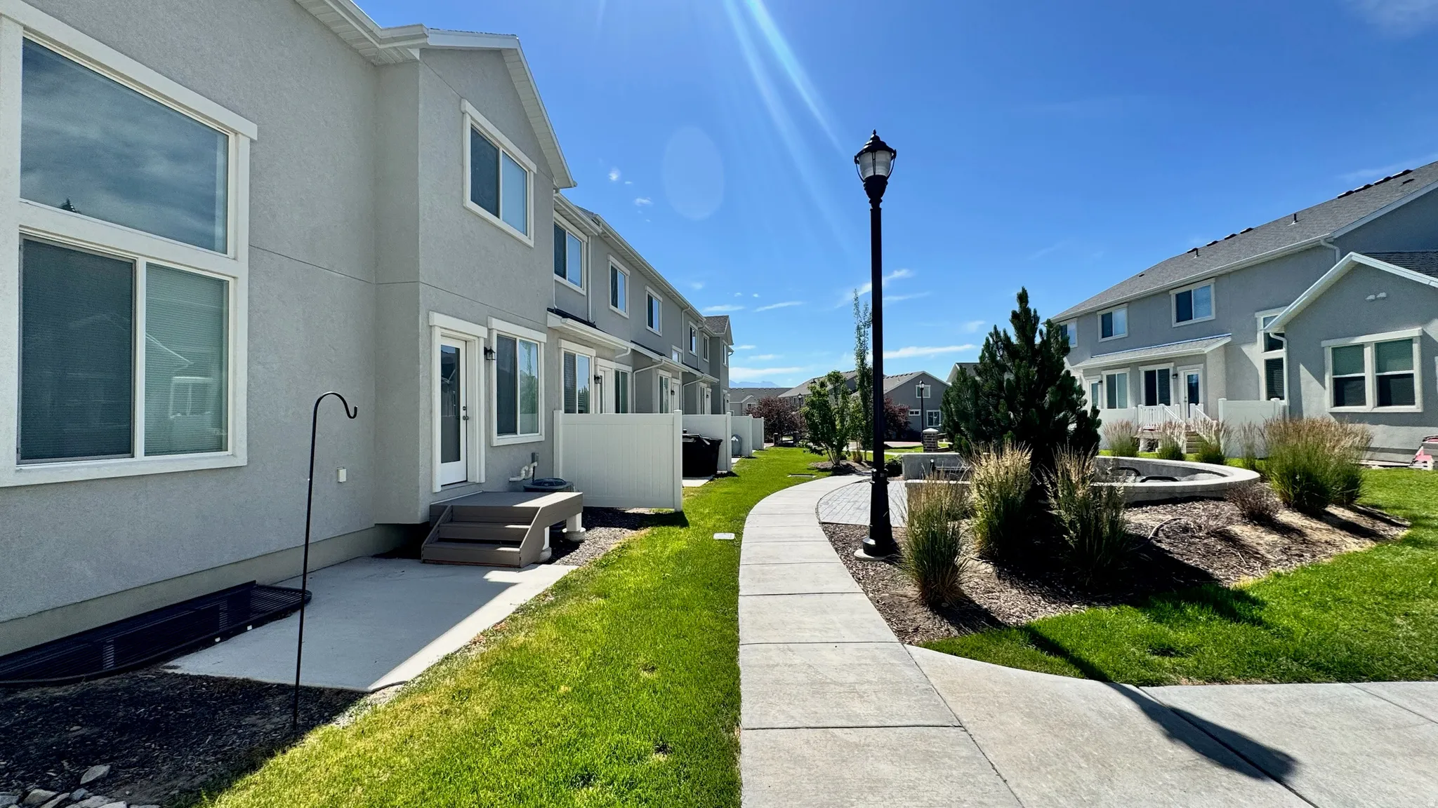 Stucco exterior featuring multiple windows and a private patio with steps