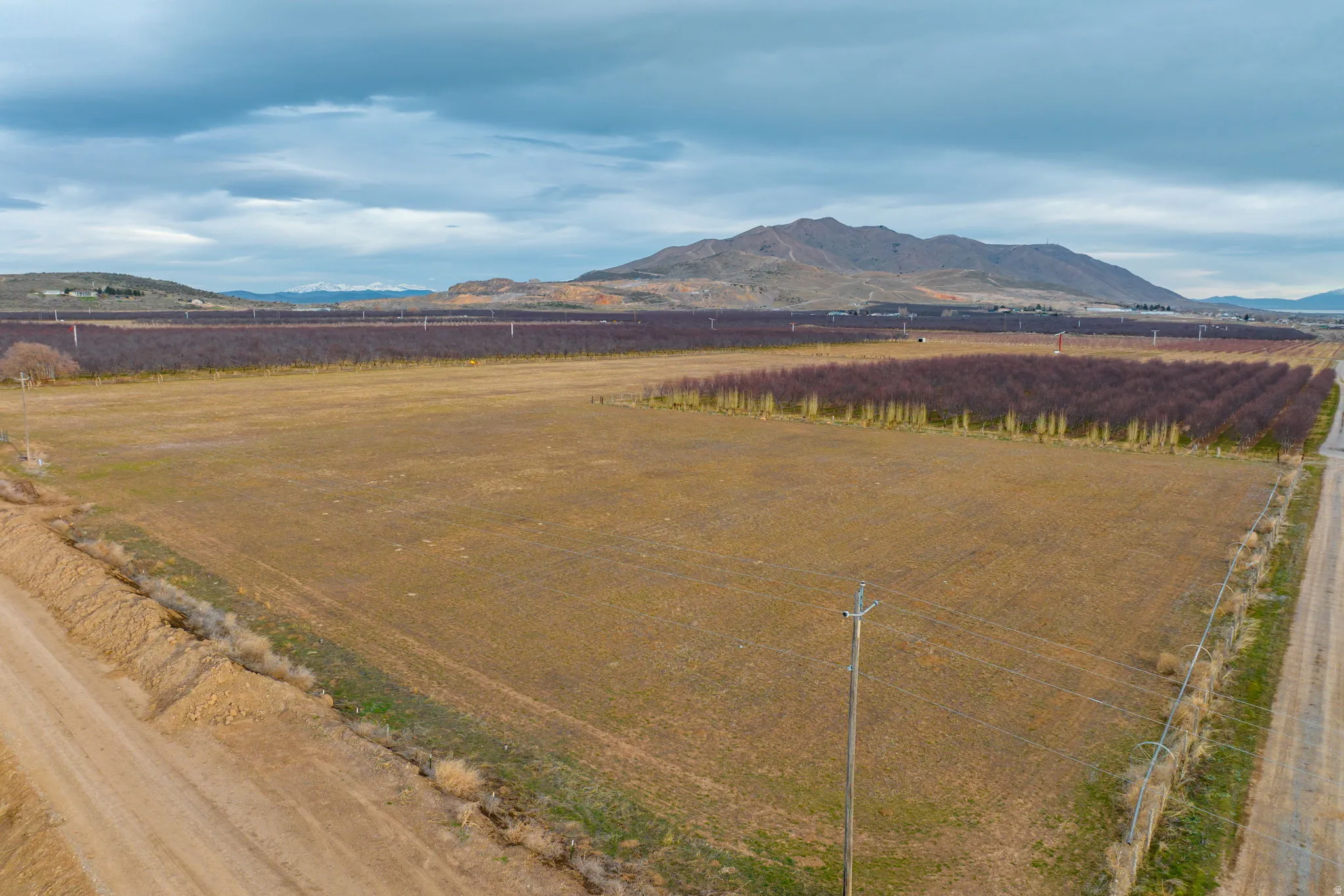 Expansive open field with surrounding agricultural land and distant mountainous terrain