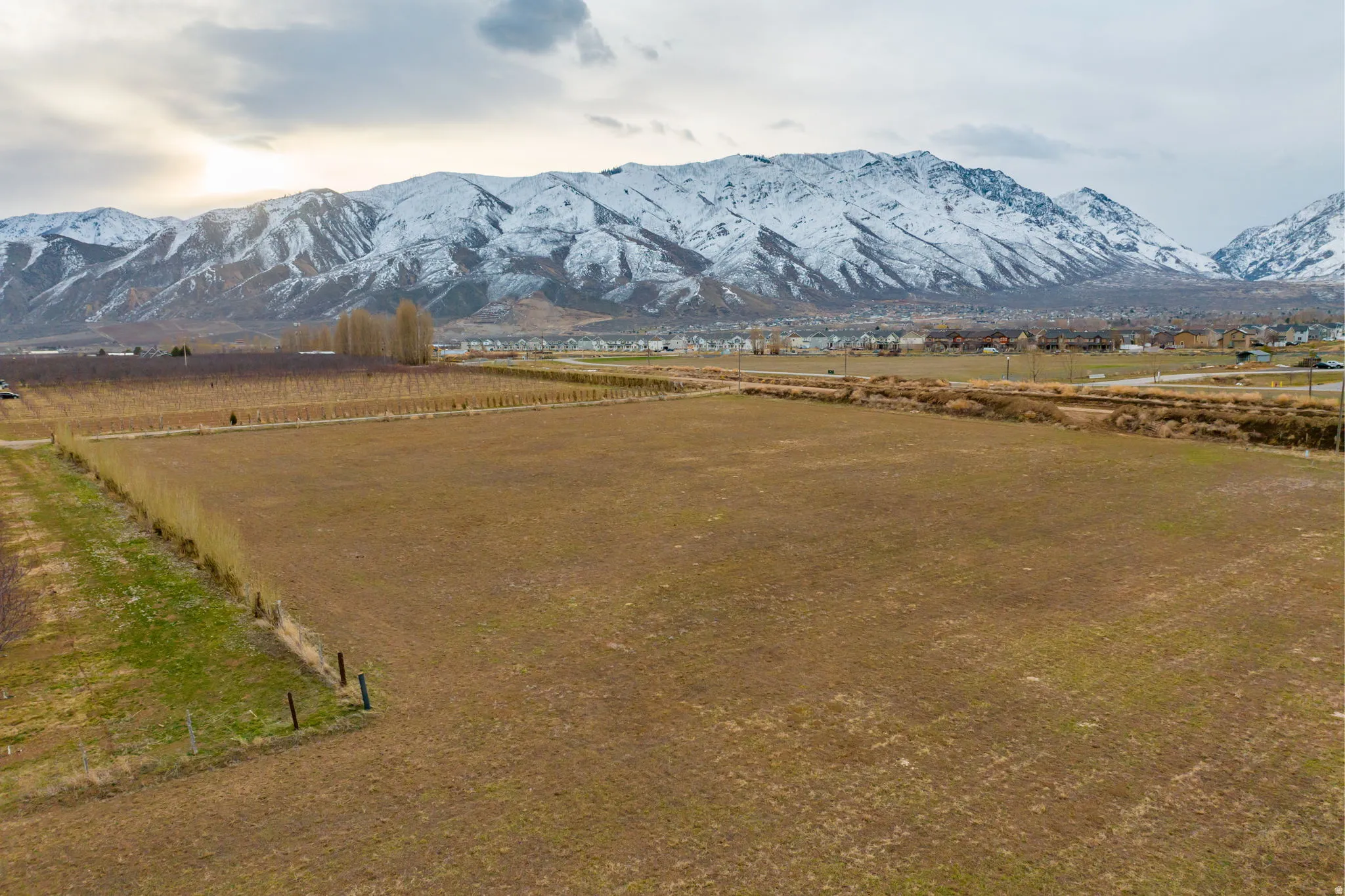 Expansive land parcel featuring clear, level terrain and a backdrop of snow-capped mountains