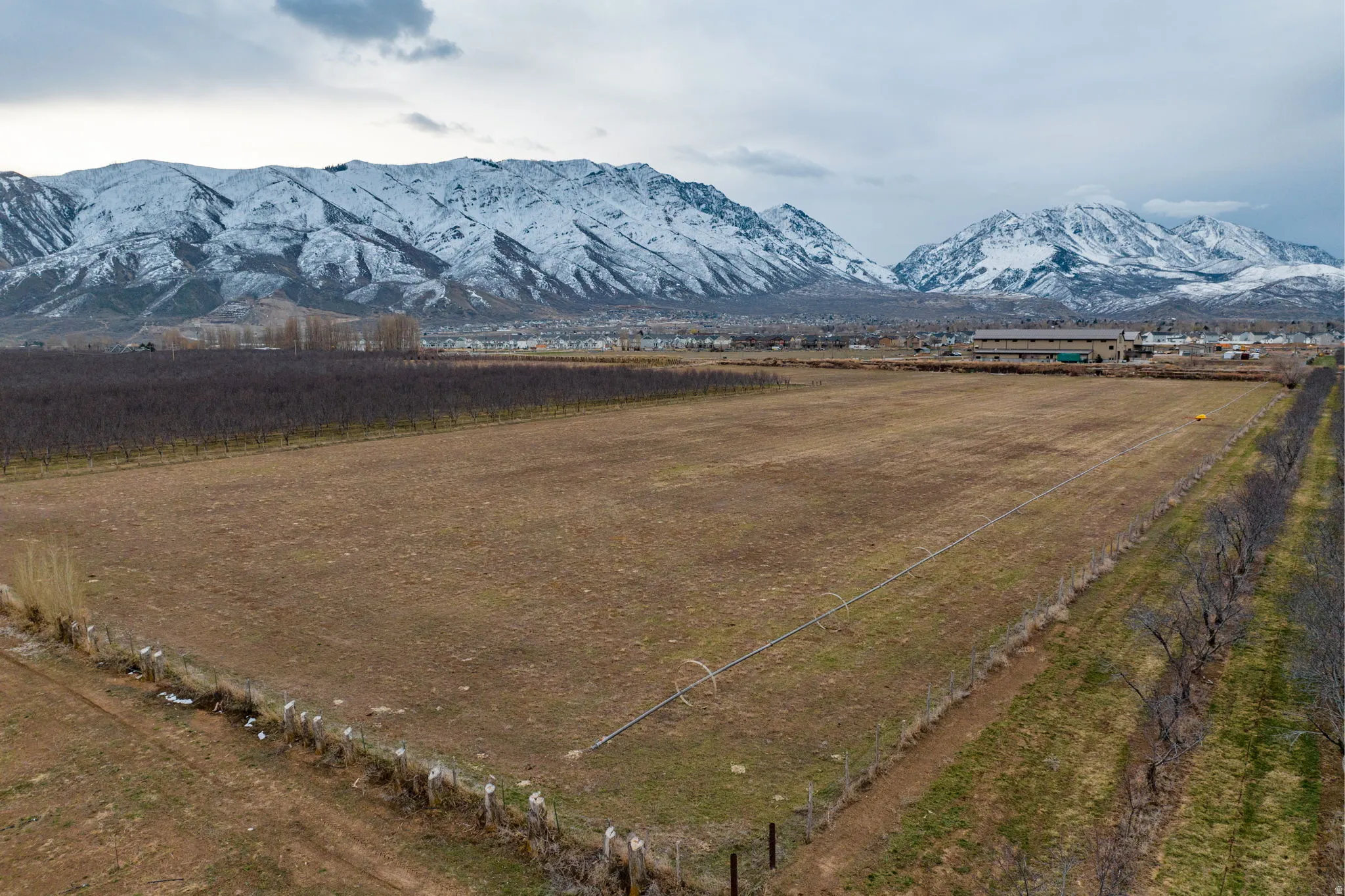 Expansive undeveloped land featuring a mountain backdrop with snow-capped peaks
