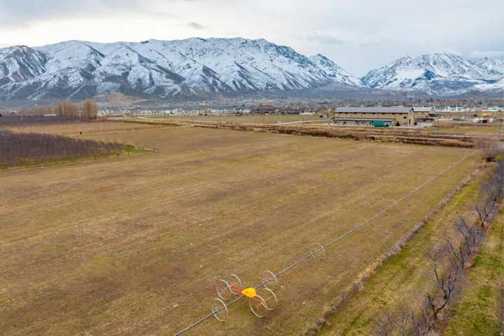 Expansive agricultural land featuring a snow-capped mountain range backdrop