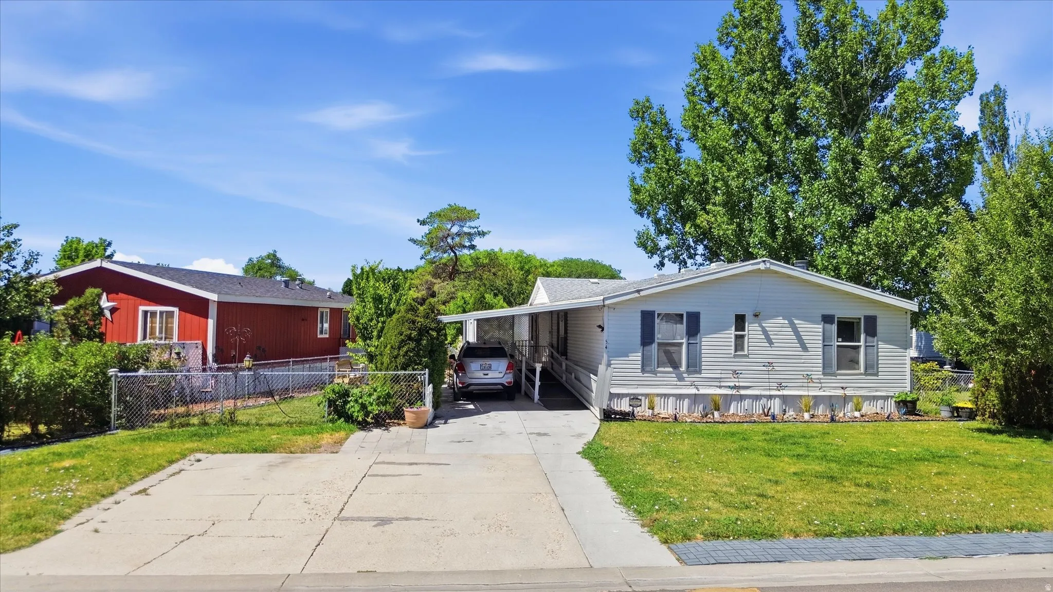 Single-story home featuring light-colored siding and a covered carport