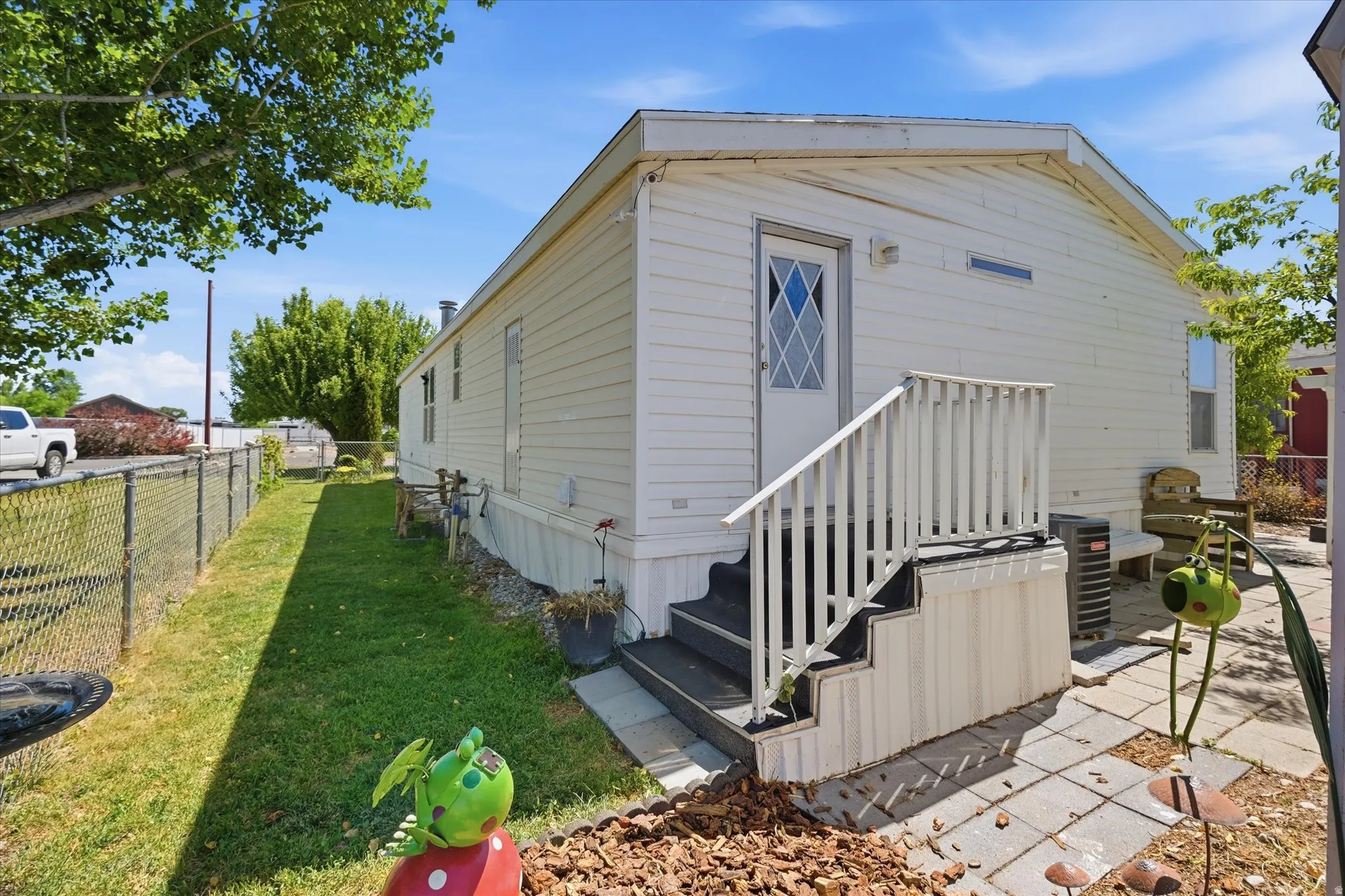 White siding exterior with a white door featuring a diamond-patterned window