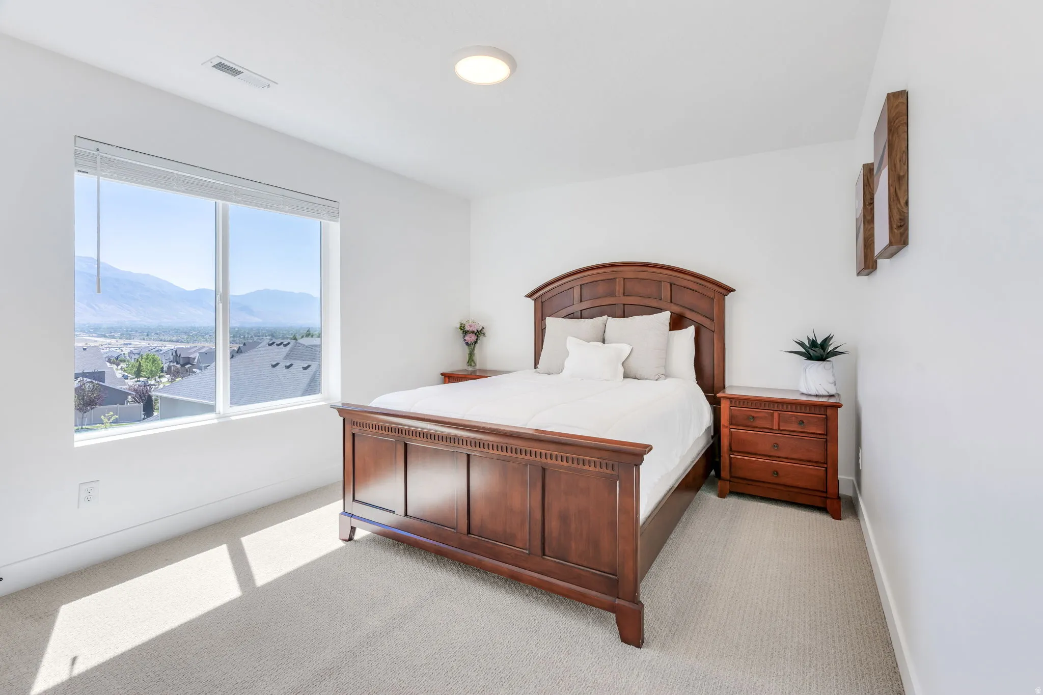 Bedroom featuring a large picture window, carpeted flooring, and white painted walls