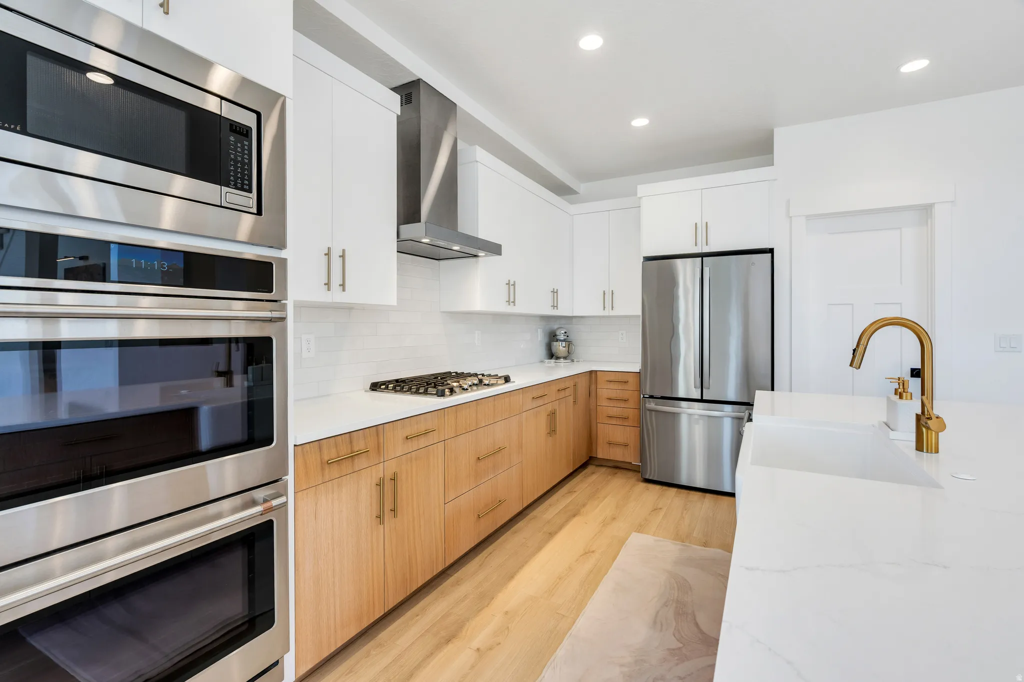 Modern kitchen featuring a gas range, stainless steel appliances, and a built-in oven and microwave