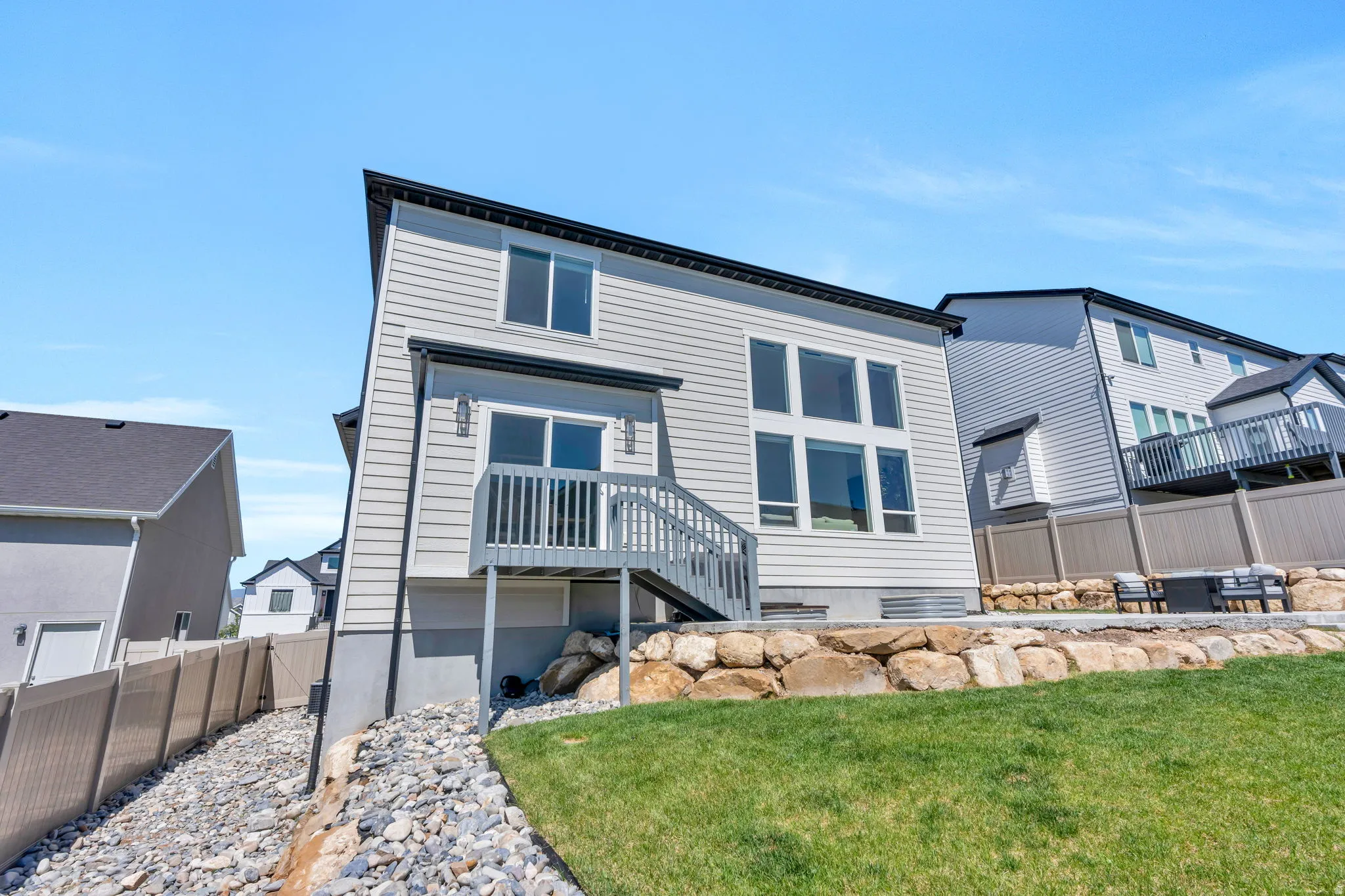 Contemporary two-story exterior with light-toned siding and dark trim