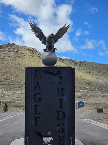 Monumental entrance sign featuring an eagle statue atop a sphere