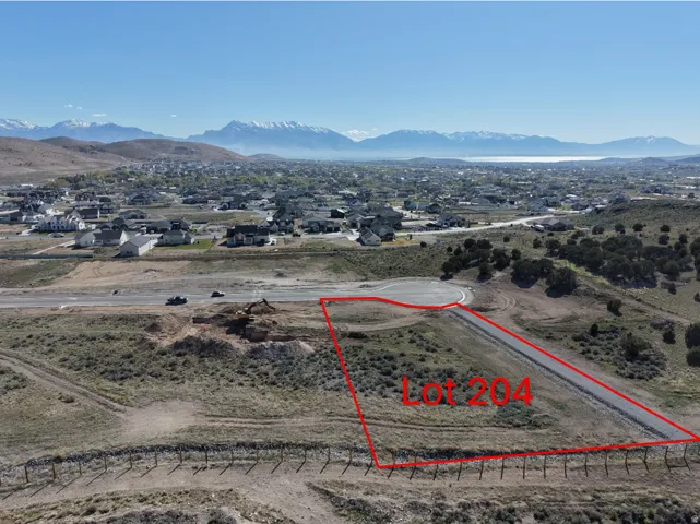 Expansive land parcel featuring a cul-de-sac street, mountain backdrop, and distant lake