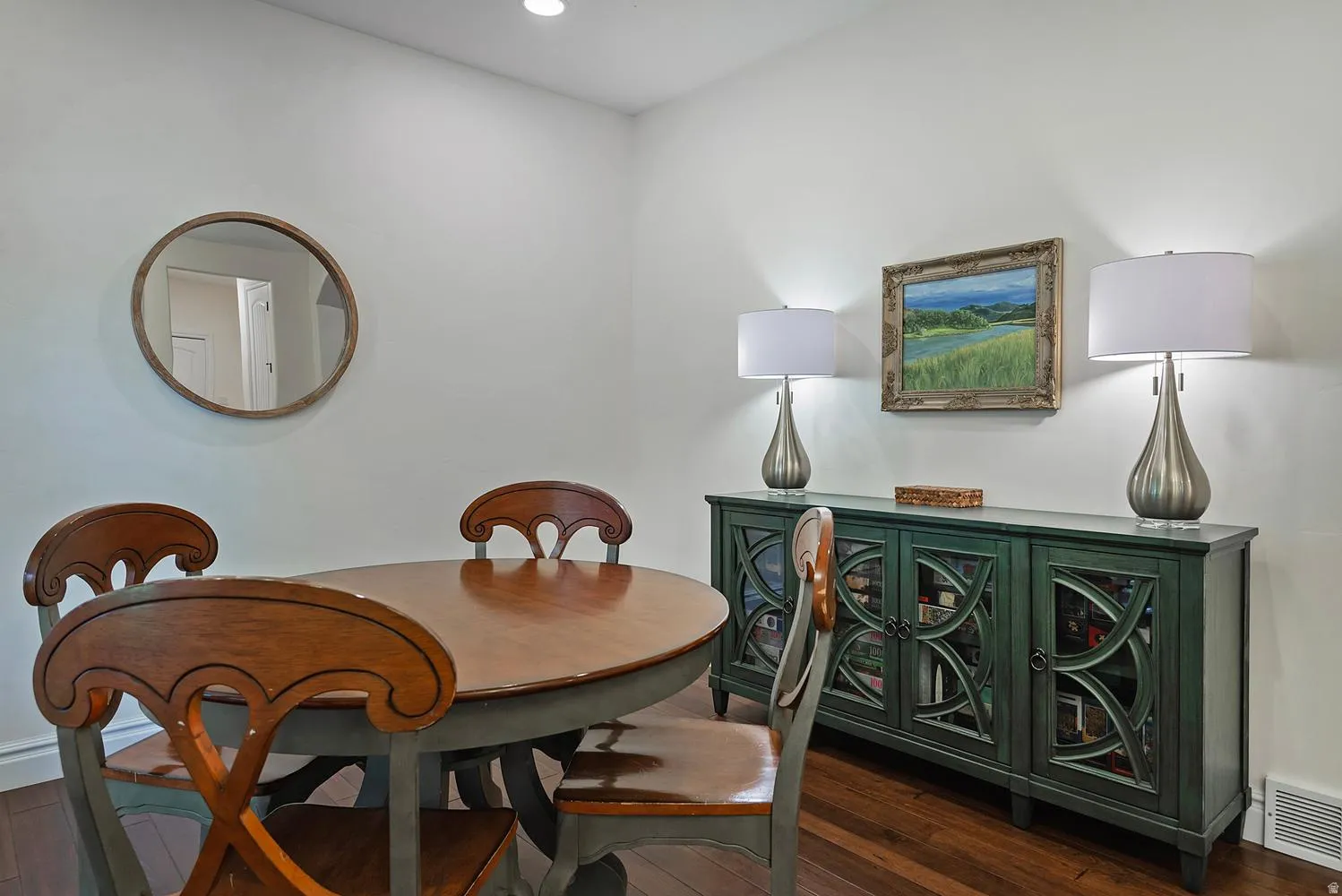 Hardwood flooring throughout this bright space featuring a built-in sideboard with decorative glass panel doors