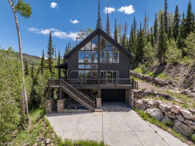 Contemporary cabin-style exterior featuring a dark gray facade and expansive A-frame windows