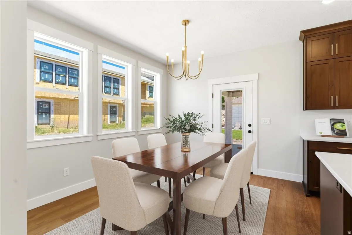 Dining area featuring warm wood-finish LVP flooring and three large windows with white trim