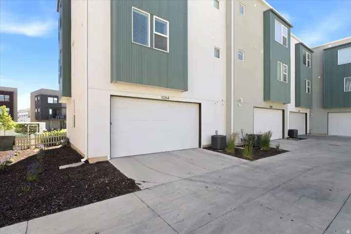 Rear exterior showcasing the oversized two-car garage and contemporary townhome design.